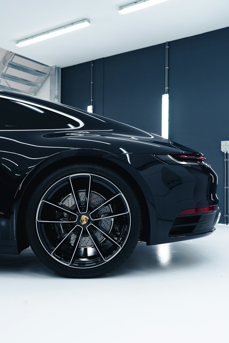 Elegante auto sportiva nera parcheggiata all'interno con carrozzeria lucida.